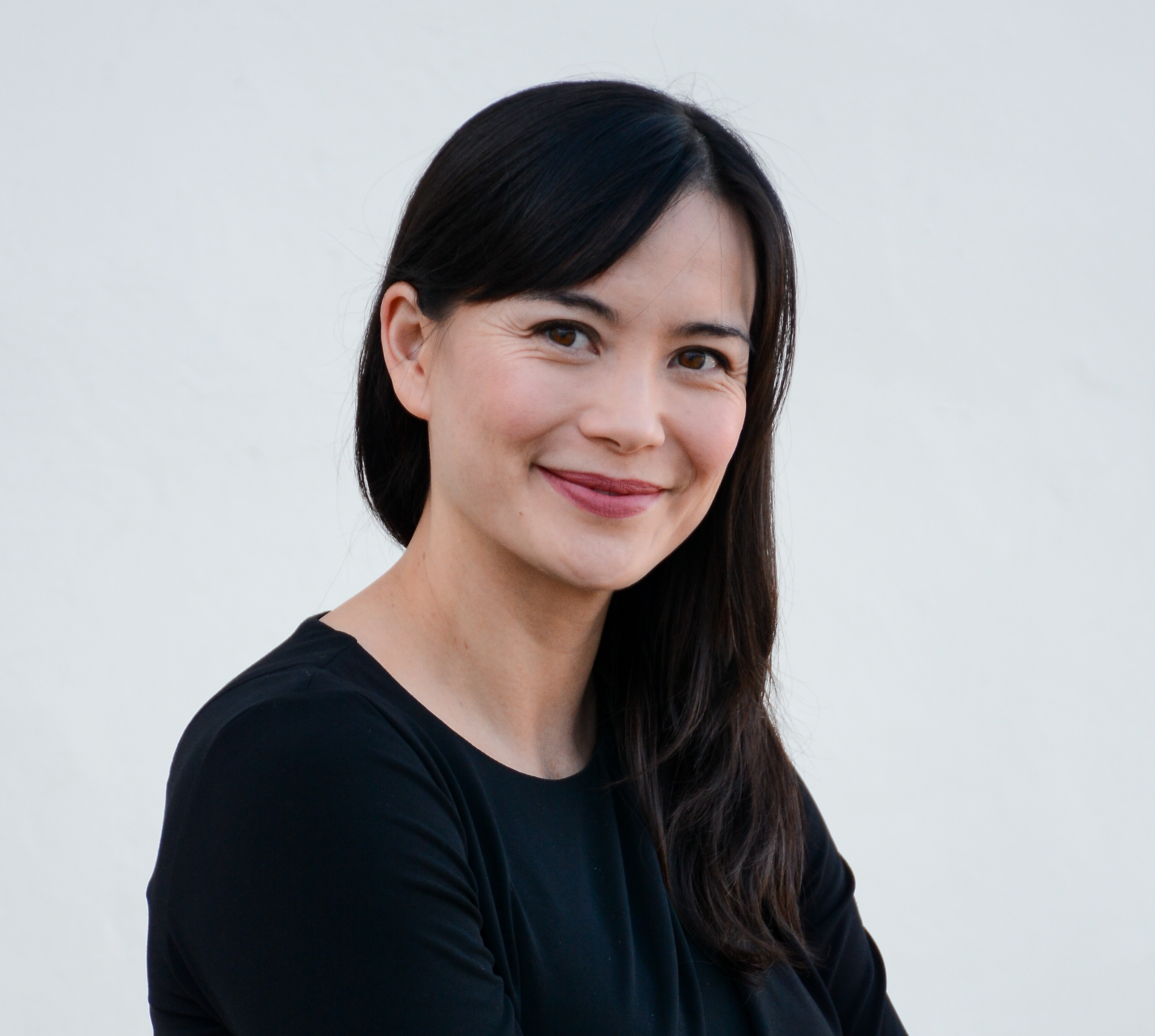 A woman with black hair wearing a black shirt